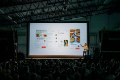An illustrative photo of a person presenting to a big audience.