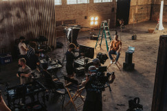An illustrative photo of a group of people standing around a camera set up.