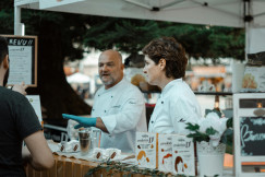 An illustrative photo of a man and a woman inside booth near man.