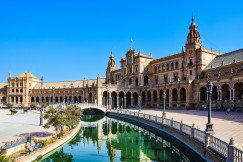 An illustrative photo of a large building with a river in front of it. 