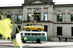 An illustrative photo of a green and white transit bus.