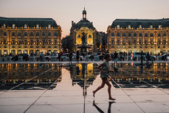 A girl running in front of a building