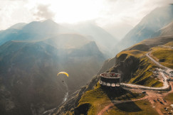 Person paragliding on the mountain cliff