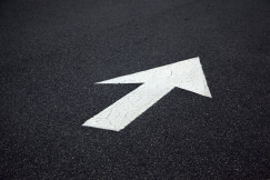Colour photograph of white arrow on black background