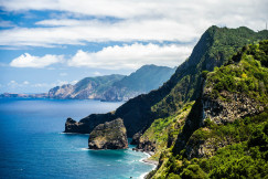 green-mountain-beside-body-of-water-under-cloudy-sky-during-daytime in Madeira
