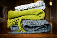 Three gray, green, and white scarf on top of table 