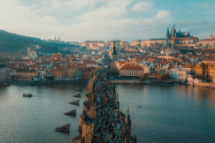 Crowded bridge over a river with city view in the background