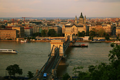 A bridge over a river with city view in the background