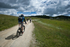 cyclists-riding-on-a-dirt-path-through-grassy-hills