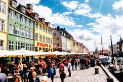 a-group-of-people-walking-down-a-street-next-to-tall-buildings