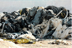 Outdoor landfill with trash and clothes gathered in piles