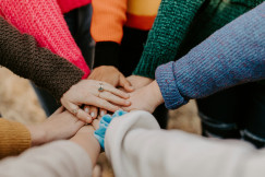 Hands stacked together in a group, showing teamwork and unity.