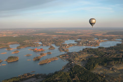 a-hot-air-balloon-flying-over-a-large-body-of-water