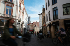 people-cycling-down-a-narrow-european-street