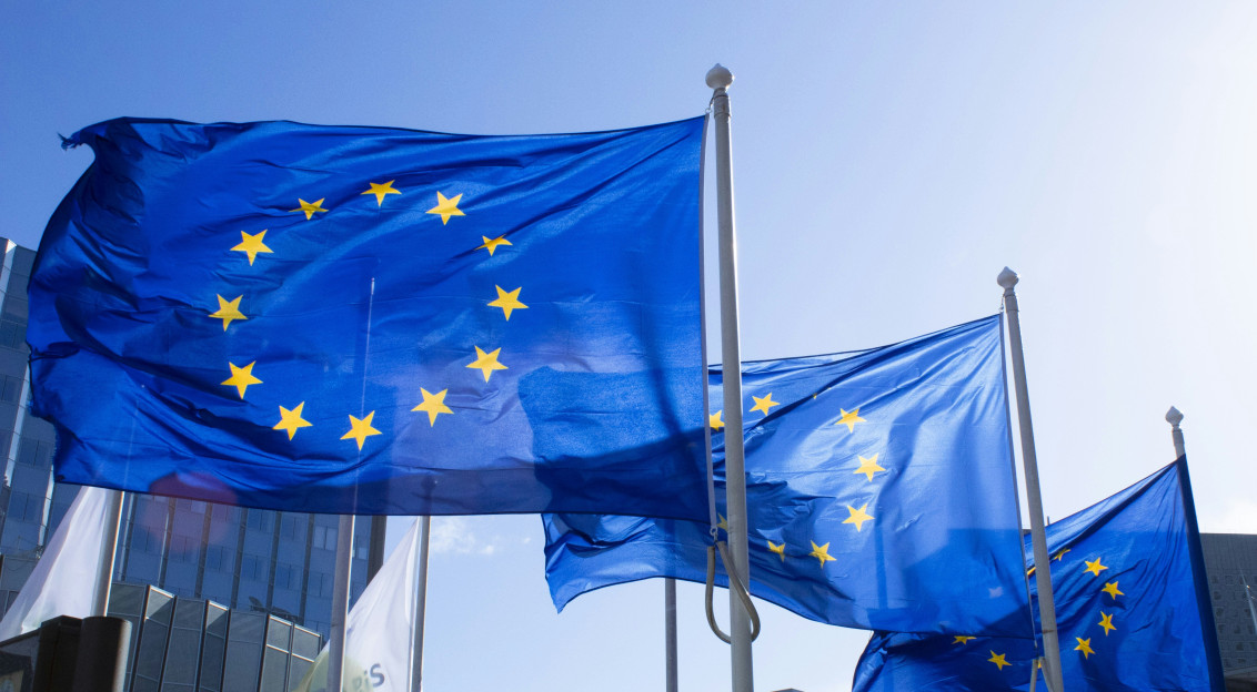 Three EU Flags waving on a pole.