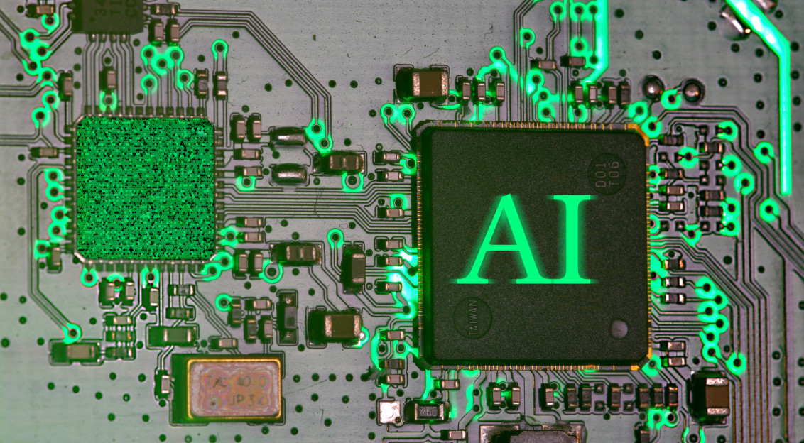 Close up image of an electronic circuit board with glowing green connections and an AI processor chip symbolising artificial intelligence and industrial digitalisation.