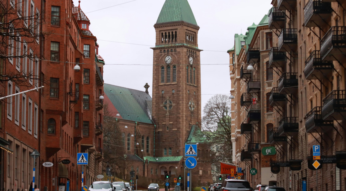 Street view leading to a church with a clock tower.