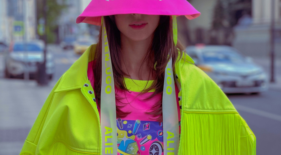 A person wearing brightly coloured contemporary fashion pieces stands outdoors, illustrating creativity, design and innovative approaches to fashion showcased at Green Fashion Week Milano 2026.