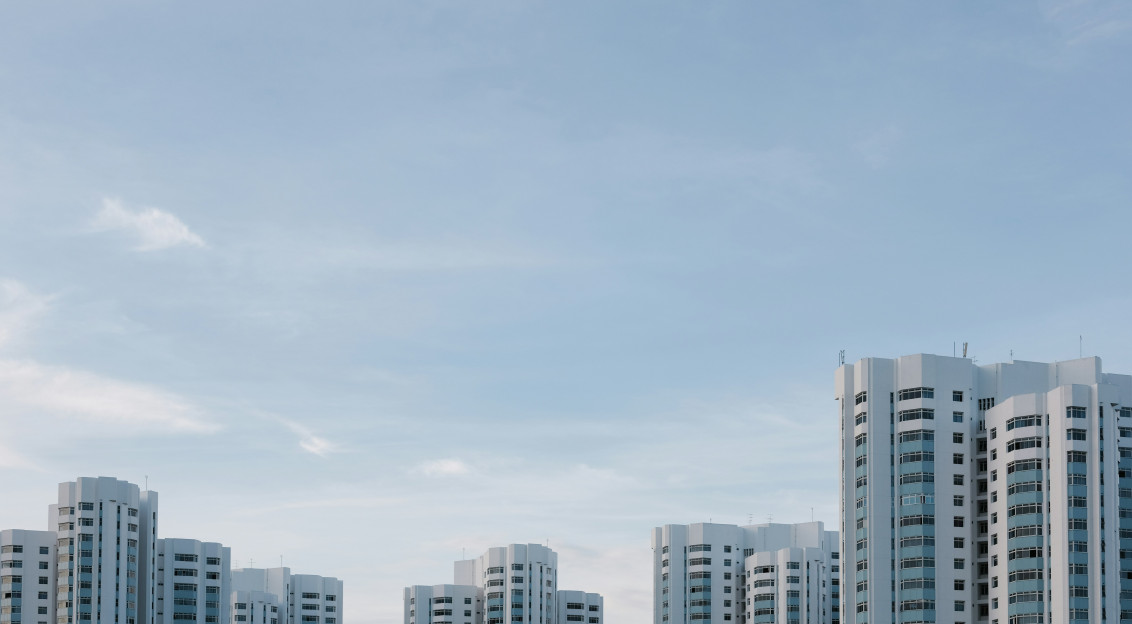 A photo presents modern residential towers under a cloudy sky.