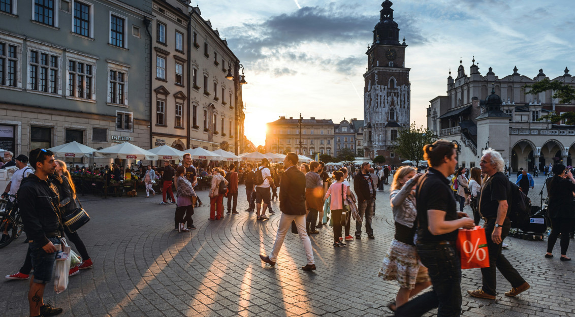 People walking on street near concrete buildings. 