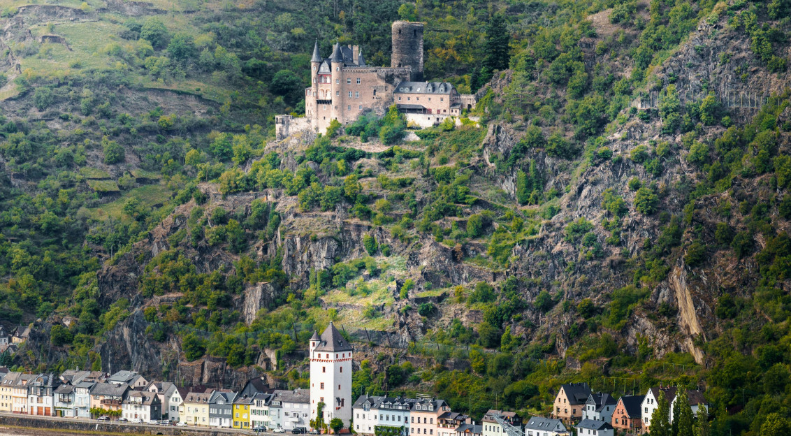 Castle ruins overlooking a river and village