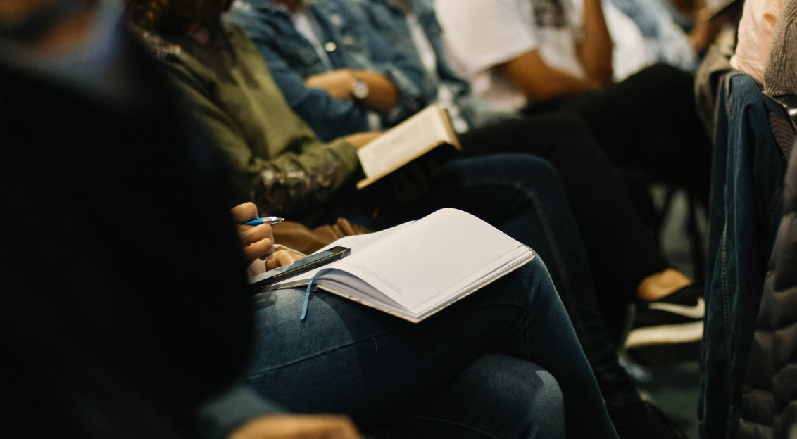 A picture presents people taking notes during an event.