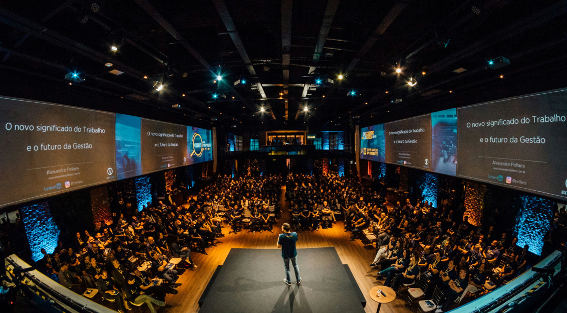 The photo presents an audience attending a conference.