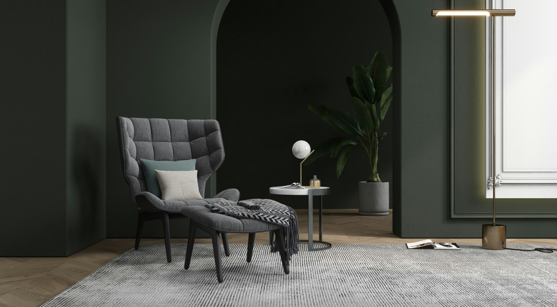 Modern interior featuring an upholstered armchair, cushions, a textile throw and a large woven rug in a contemporary living space.