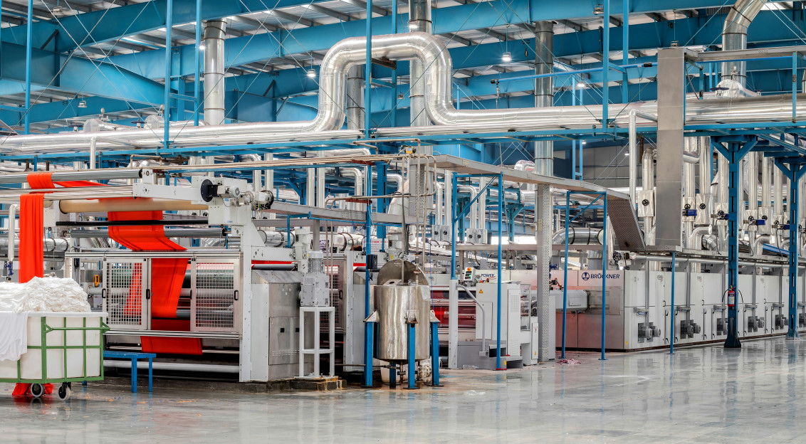 Modern textile manufacturing facility with industrial machinery, fabric processing equipment and production lines