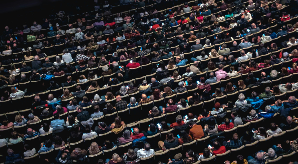 A large group of people sitting in a theatre.