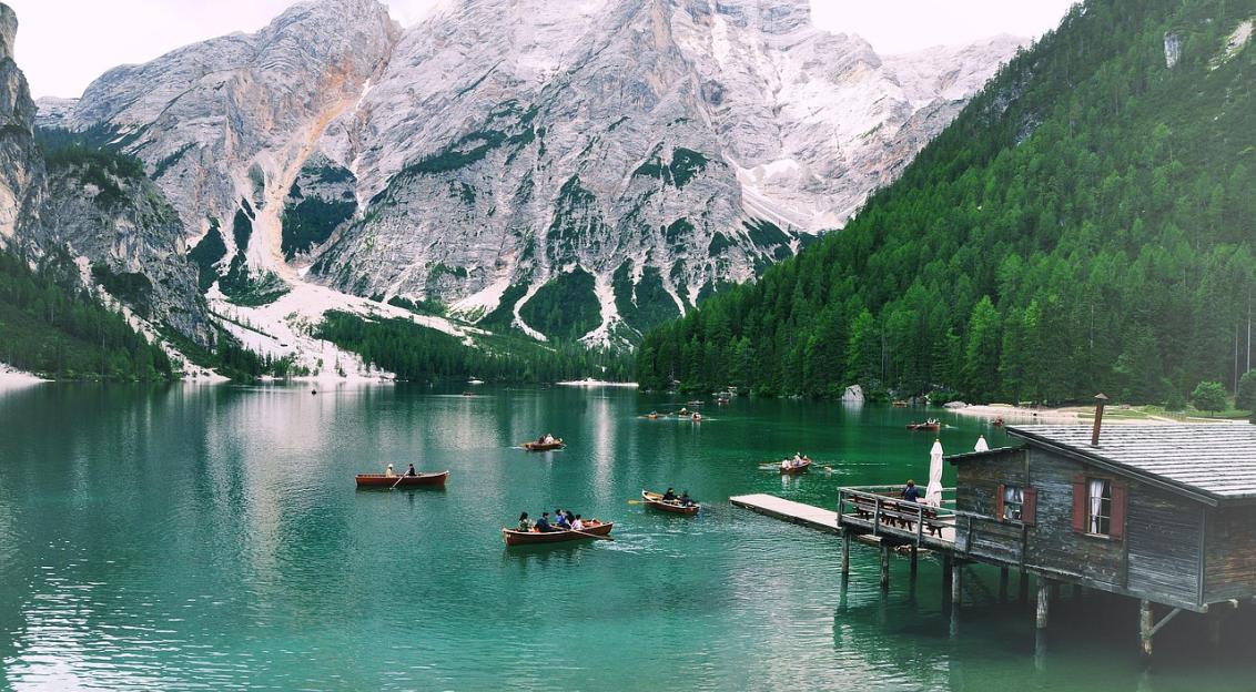 An illustrative photo of boats in a body of water with snowy mountains in the background