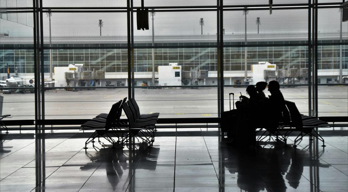An illustrative photo of people sitting on chairs in airport.