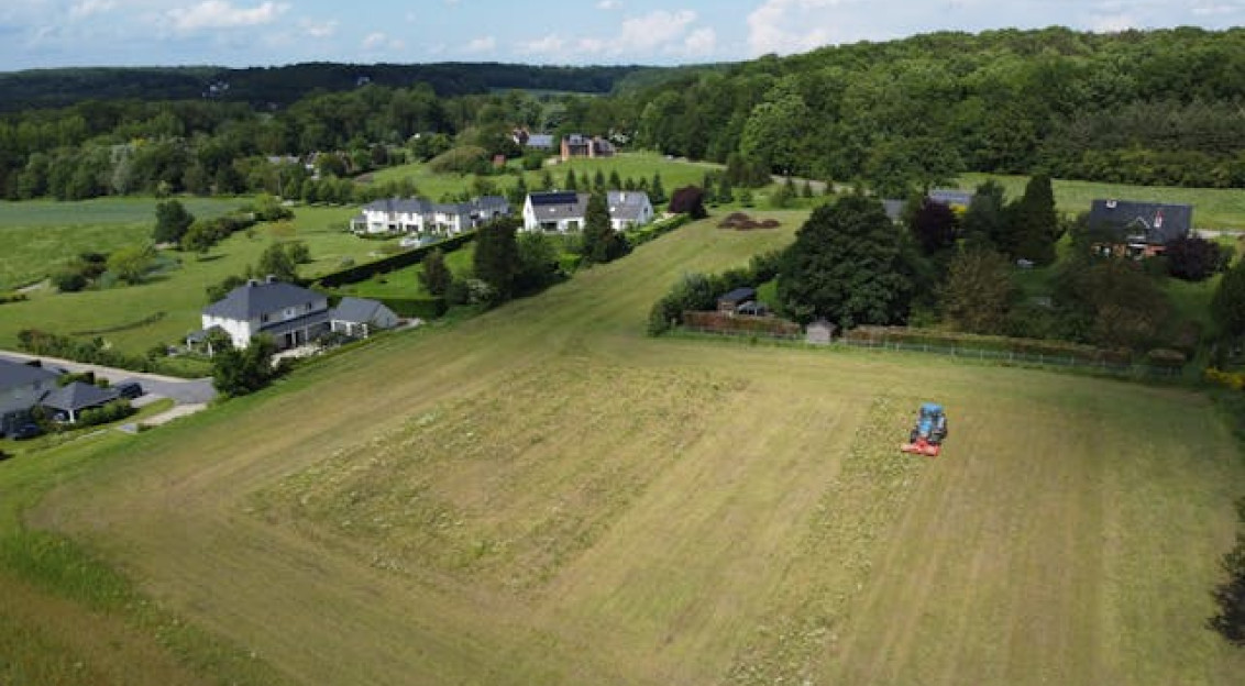 Photo by Pexels An illustrative photo of a field with a tractor and houses