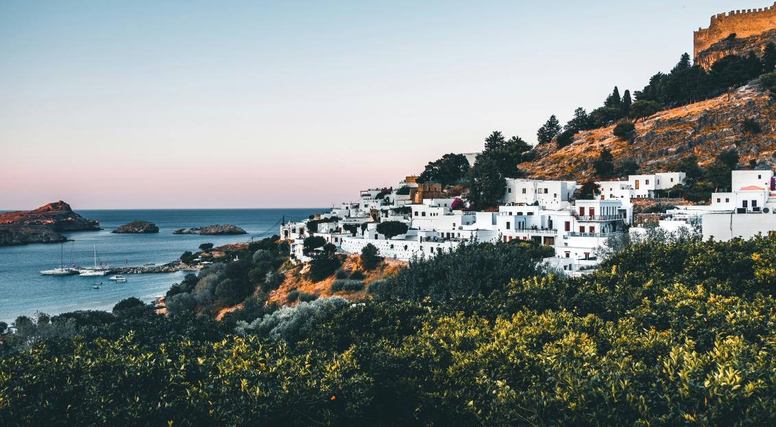 Photo by Unsplash An illustrative photo of white buildings on mountain by the sea.