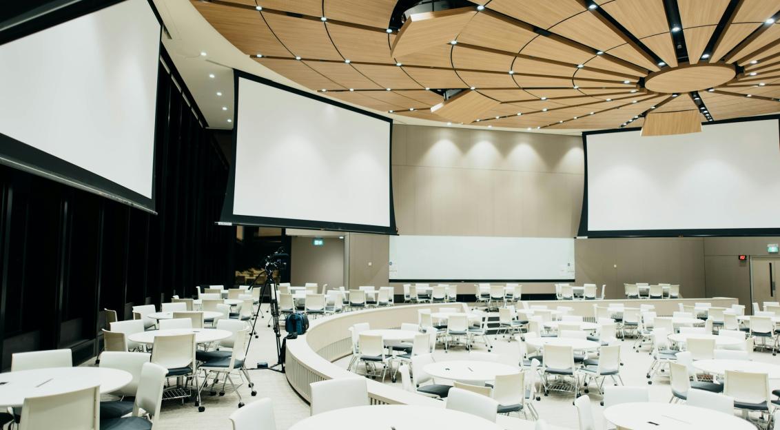 An illustrative photo of empty room with projector screen.