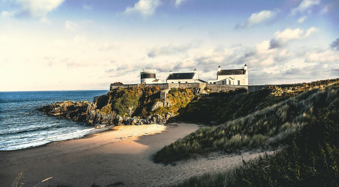 Photo by Unsplash An illustrative photo of three white concrete houses on sea cliff.