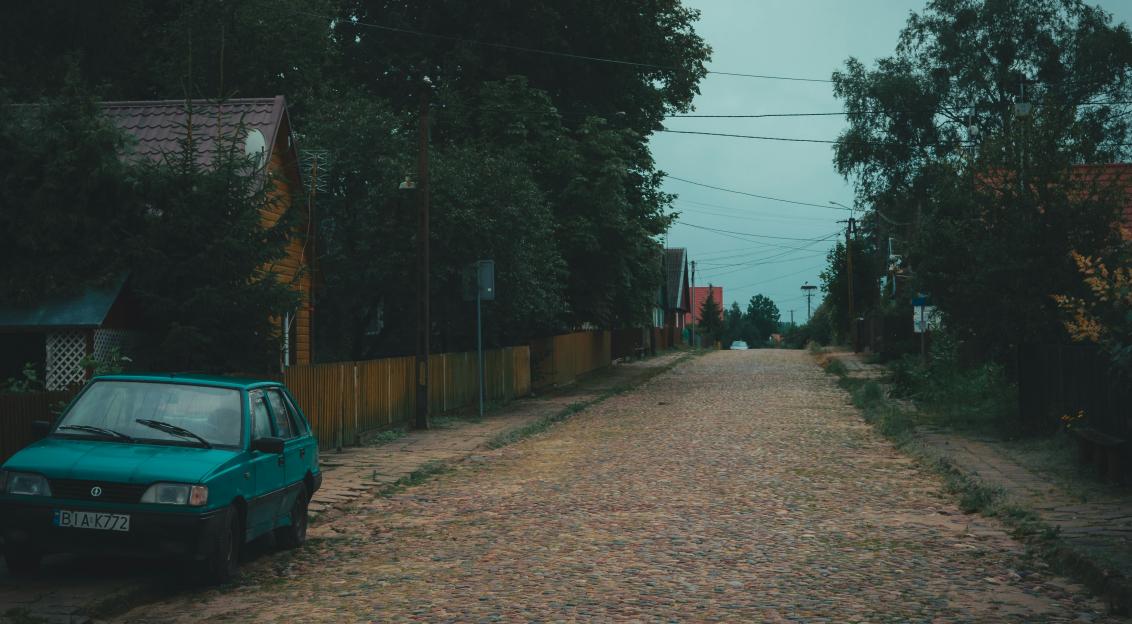 Photo by Unsplash An illustrative photo of a green car parked beside brown wooden fence during daytime
