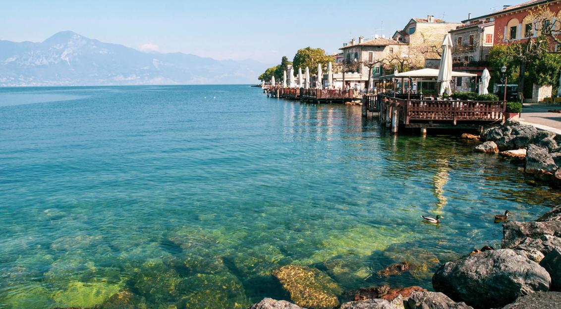 Photo by Pexels An illustrative photo of a beach scene with clear sea water and charming cottages along the shoreline