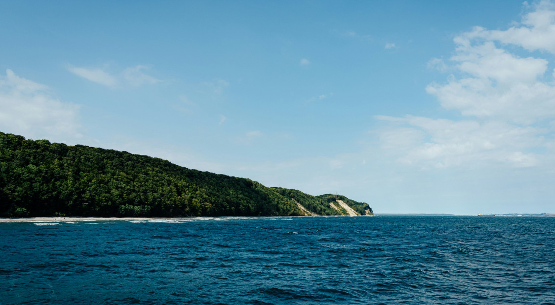 Photo by Unsplash An illustrative photo of a green mountain beside blue sea