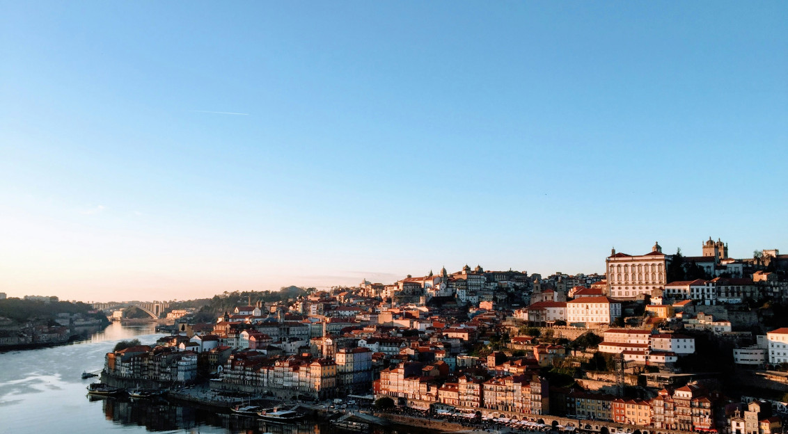 An illustrative photo of city buildings near river under blue sky