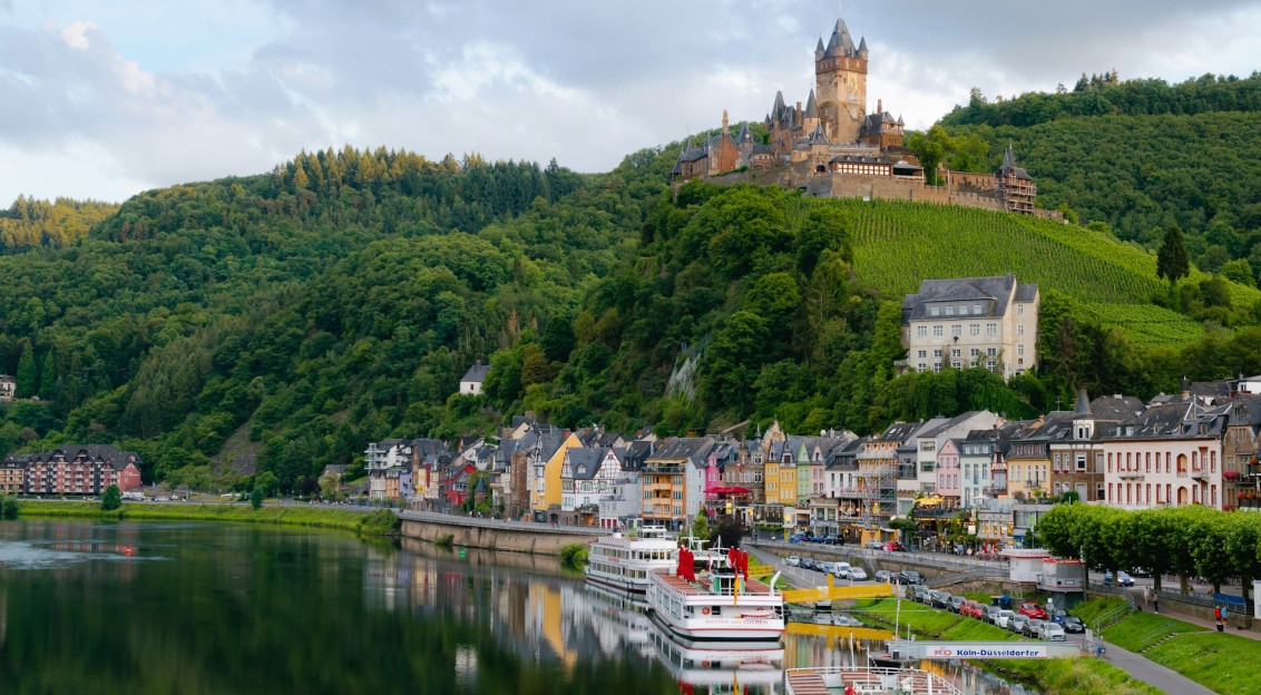 Photo by Unsplash An illustrative photo of buildings near a body of water and a green hill