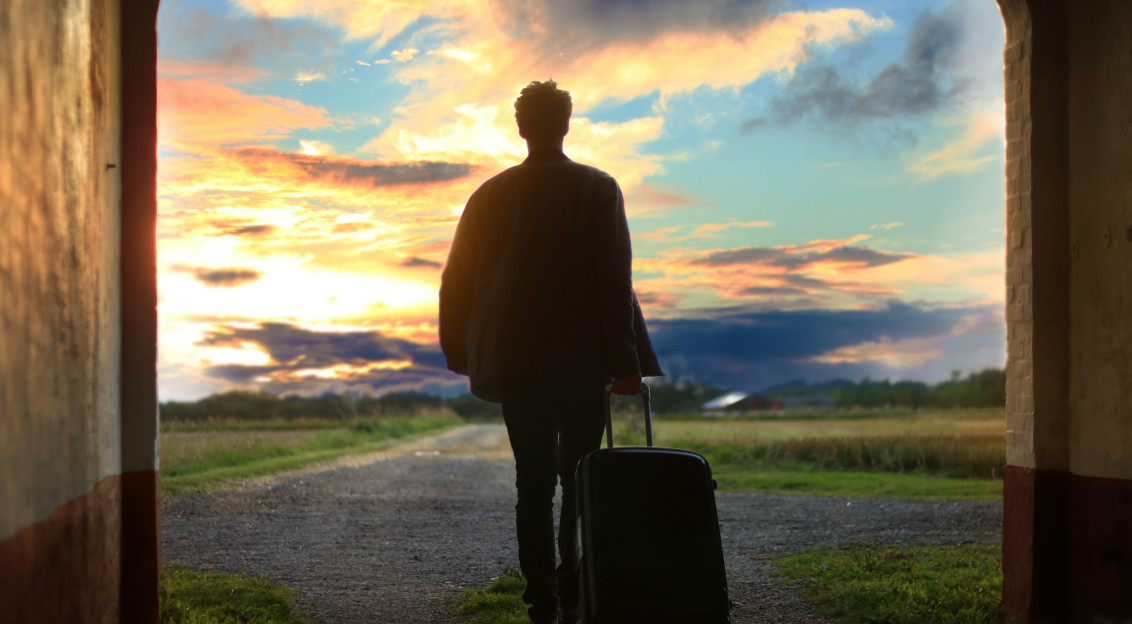 An illustrative photo of a man holding a luggage.