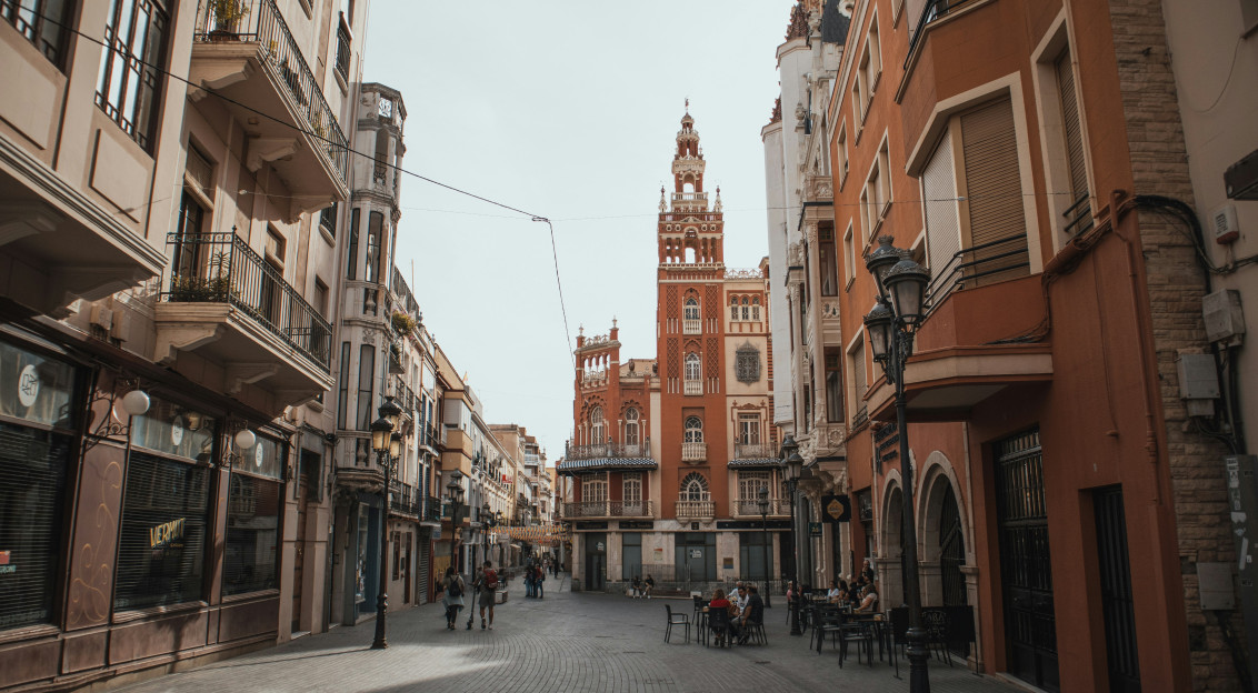 An illustrative photo of a city street lined with tall buildings and a clock tower