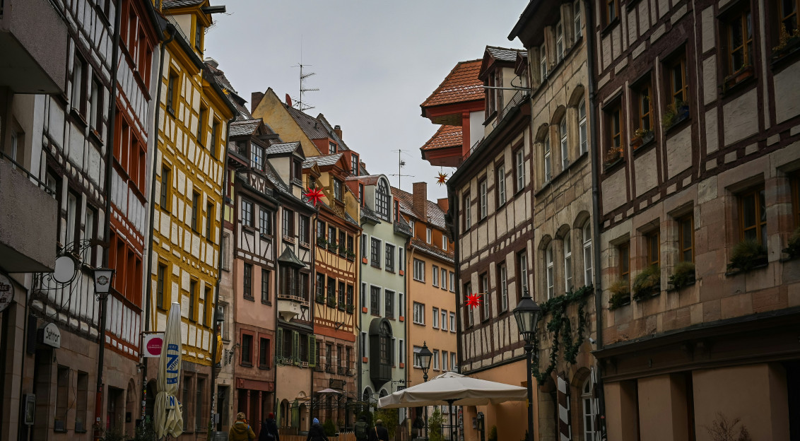 Photo by Unsplash An illustrative photo of people walking on a narrow street in Germany