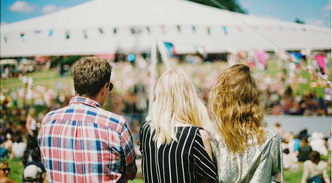 An illustrative photo of three people standing on a festival