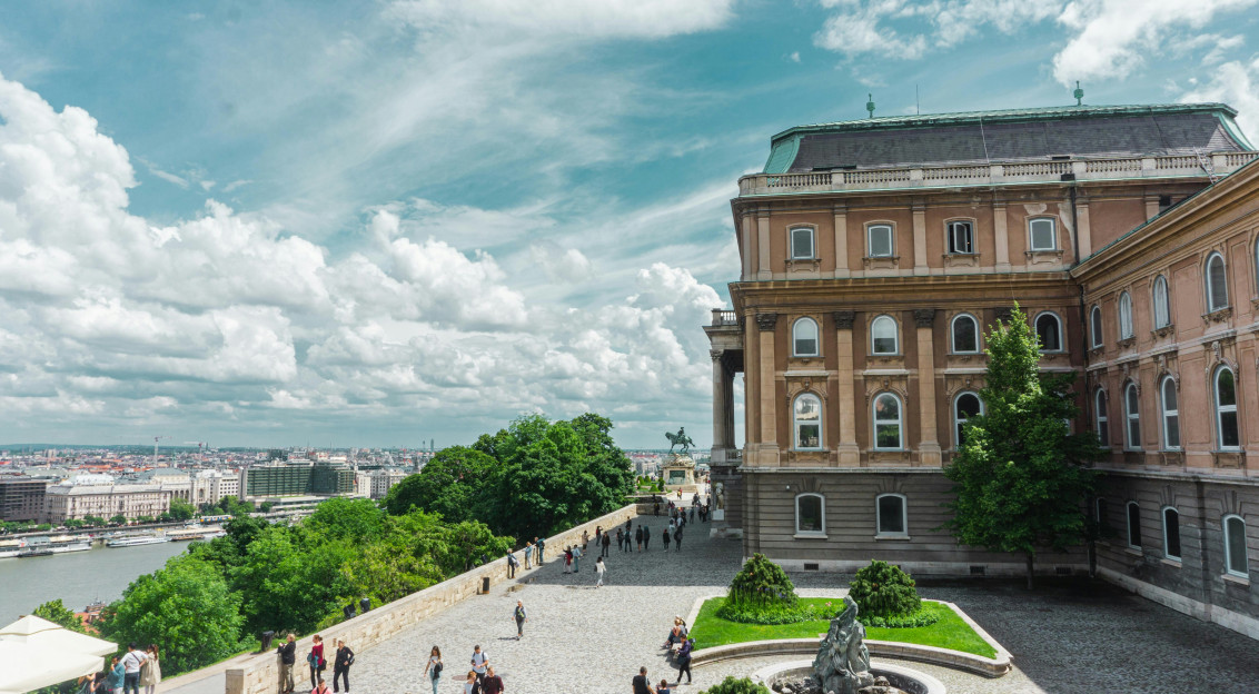 An illustrative photo of people walking on park near brown concrete building