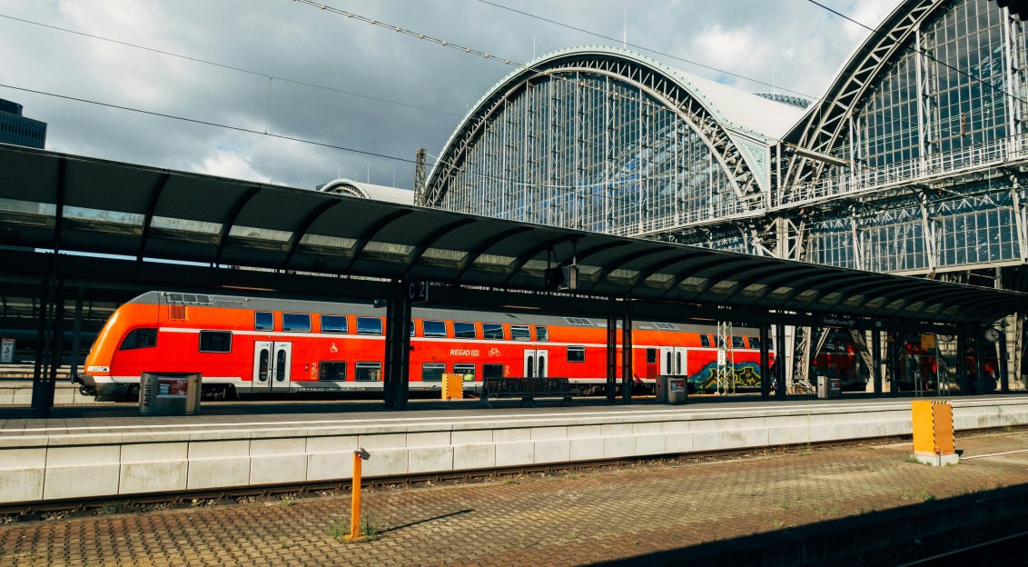 Image by Unsplash An illustrative photo of a red and white train on rail tracks.