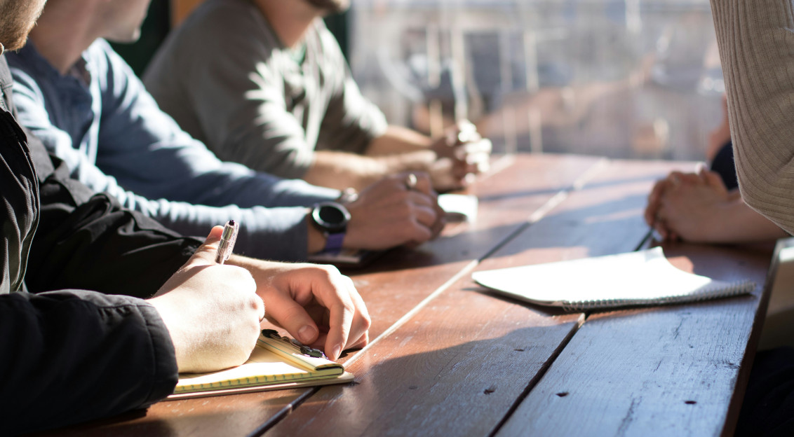Photo by Unsplash An illustrative photo of people writing notes while discussing something