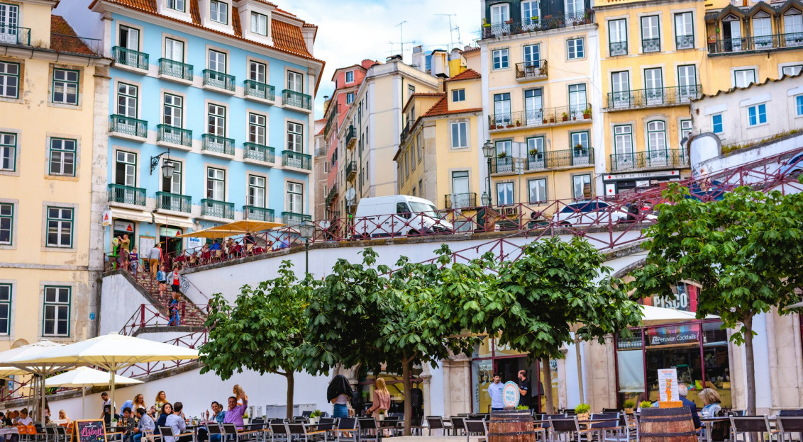 An illustrative photo of people walking on street near colourful buildings during daytime