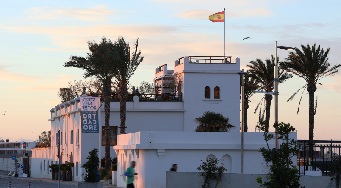 Photo by Unsplash An illustrative photo of a white building with a Spanish flag on top of it